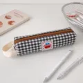 Dettaglio di un astuccio a scacchi bianchi e neri con cerniera marrone ed etichetta - Plaid Nero