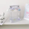 Close-up of kawaii milk carton shaped transparent PVC bag for plush doll display and storage - Purple