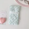 Detail van een gewatteerd lichtblauw etui met stippen en hartvormige kanten rand - Muntgroen