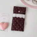 Gedetailleerd overzicht van de bruine gewatteerde tas met hartjeskant en roze knoop - Bruin