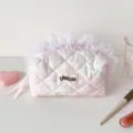 Détail d'une trousse à maquillage matelassée rose avec dentelle blanche et motifs fleuris - Garniture en Dentelle Rose