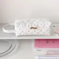 Vue détaillée du motif de cœur matelassé et du logo de la marque sur ce sac de papeterie - Long Blanc (avec poignée)