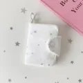 Macro di un mini portafoglio bianco a coste con motivi a stelle argentate e un gancio - Stella Bianca