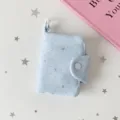 Primo piano dettagliato di un mini portacarte azzurro con motivi a stelle argentate - Stella blu