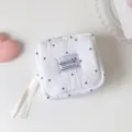 Detalle de un neceser blanco con lunares minimalista y etiqueta de tela Hisocute - Lunares Blancos