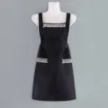 Grembiule da cucina nero con elegante bordo in pizzo bianco, perfetto per cucinare. - Nero