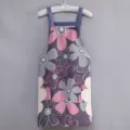 Dettaglio in primo piano del grembiule da cucina con stampa floreale e panni laterali. - Stile Asciugamani / Violetto