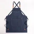 Grembiule in tela di jeans spessa con spalline incrociate, tasche multiple e dettagli in pelle. - Blu
