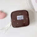 Detalle de neceser marrón acolchado con lunares y etiqueta HISOCUTE - Lunares Marrón