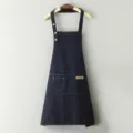 Delantal de trabajo de lona oscura con tirantes cruzados y bolsillos de cocina. - Azul
