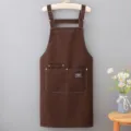 Grembiule in tela marrone con spallacci regolabili e tasche, abbigliamento da lavoro. - Caffè