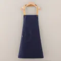 Grembiule da lavoro in cotone blu scuro con spalline kaki e tasca frontale appeso alla gruccia - Blu