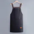 Waterproof kitchen apron with cross-back straps and pockets, ideal for cooking and work. - Regular Fit / Black