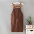 Grembiule in tela marrone con spallacci arancioni e tasche, ideale per caffè e panetteria. - Stile Bretelle / Caffè