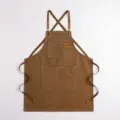 Klassische braune Canvas-Arbeitsschürze mit Kreuzgurt und Taschen für Küche und Café. - Kaffeebraun