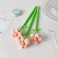 Detail view of green pens with decorative pink fabric polka-dot flowers on top. - Orange