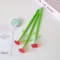 Detailed macro shot of three creative red rose flower ballpoint pens with green stems. - Red