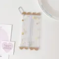 Close-up of a clear PVC mini doll storage pouch with cute prints and a white bead chain - Brown