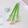 Close-up of creative pink crystal rose pens with green stems on a clean desk. - Pink