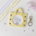 Detailed view of yellow mini handbag-shaped badge display sleeve with window - Including Four Ribbons in Two Colors / Yellow