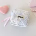 Vista detallada de una bolsa de tela acolchada con flores azules y lazo rosa - Pequeño floral azul