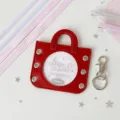 Close-up of red mini handbag badge holder with transparent window for photos - Including Four Ribbons in Two Colors / Dark Red