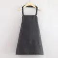 Delizioso grembiule da cucina corto nero con tasche e bottoni metallici appeso su gruccia in legno - Halter Neck / Halter Nero