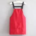 Short red kitchen apron with black straps and convenient front pockets for cooking. - Strap Style Red