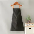Delantal negro de lona con tirantes marrones y bolsillo frontal para café, cocina y panadería. - Cordón de cuello / Negro