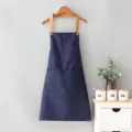 Delantal de lona azul oscuro con tirantes marrones y prácticos bolsillos para cocina. - Cordón de cuello / Azul