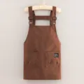 Brown canvas work apron with adjustable straps and pockets, ideal for kitchen and baking. - Coffee