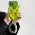 Green wavy phone case featuring a large fabric bow and fuzzy plush wrist strap for women. - Mustard Green 3D Bowknot / Samsung A11