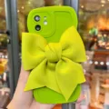 Custodia per smartphone verde brillante con grande fiocco in tessuto e bordi strutturati per donne. - Fiocco grande 3D verde senape