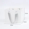 Vista dettagliata della borsa regalo in carta bianca con forma quadrata e manico in nastro. - Piccolo Sacchetto Regalo Gen 2 / 5 Pezzi/Confezione / Bianco
