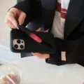 Close-up detail of black silicone phone case with integrated lipstick holder slot. - Black / iPhone 13
