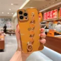 Glossy caramel brown iPhone case featuring a stylish gold heart chain wrist strap. - Brown Heart Wrist Chain