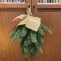 Künstlicher Tannenzweig Swag mit rustikaler Juteschleife für weihnachtliche Hängedeko - Wandbehang Weihnachtsbaum