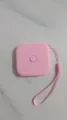 Dettaglio del metro a nastro quadrato rosa retrattile con comodo cordino per uso quotidiano. - Rosa