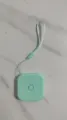 Primo piano di dettaglio del metro a nastro quadrato verde menta con pratico cordino. - Verde