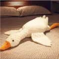 Vista dettagliata del peluche d'oca bianca sdraiato sul letto, morbido e confortevole. - 90cm / Peluche a pois
