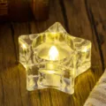 Transparent star shaped LED tea light candle with warm yellow glow on wooden background - Star Style