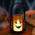 Halloween LED candle lamp with jack-o'-lantern face in a black metal U-shaped frame - Handbag Style / Orange