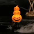 Glowing three tier stacked Halloween pumpkin Jack o lantern lamp on a black pedestal stand - Pumpkin Candle Holder Lamp