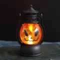 Lanterne de citrouille d'Halloween vintage avec lueur LED orange sur vieux livre - Lanterne Noire Yeux Obliques