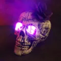 Halloween decorative skull head with purple LED glowing eyes and purple rose ornament - Glowing Skull With Purple Flower Decoration