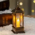 Lanterne LED vintage en bronze avec bougie électronique sur fond de fausse neige - Bronze