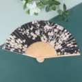 Detailed shot of traditional Japanese folding fan with black paper and floral pattern. - 6.5 Inch / Plum Blossom Black Surface