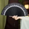 Traditional Chinese folding fan with black silk lace fabric, bamboo ribs and tassel ornament. - Black Crown Style with Pendant / Black