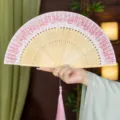 Traditional Chinese folding fan with pink lace, silk surface, and bamboo handle for Hanfu. - Pink Crown Style with Pendant / Pink