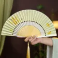 Éventail pliant chinois traditionnel en soie avec motif de feuilles de ginkgo et beau pompon - Papillon Ginkgo Jaune Clair/Poignée Blanche